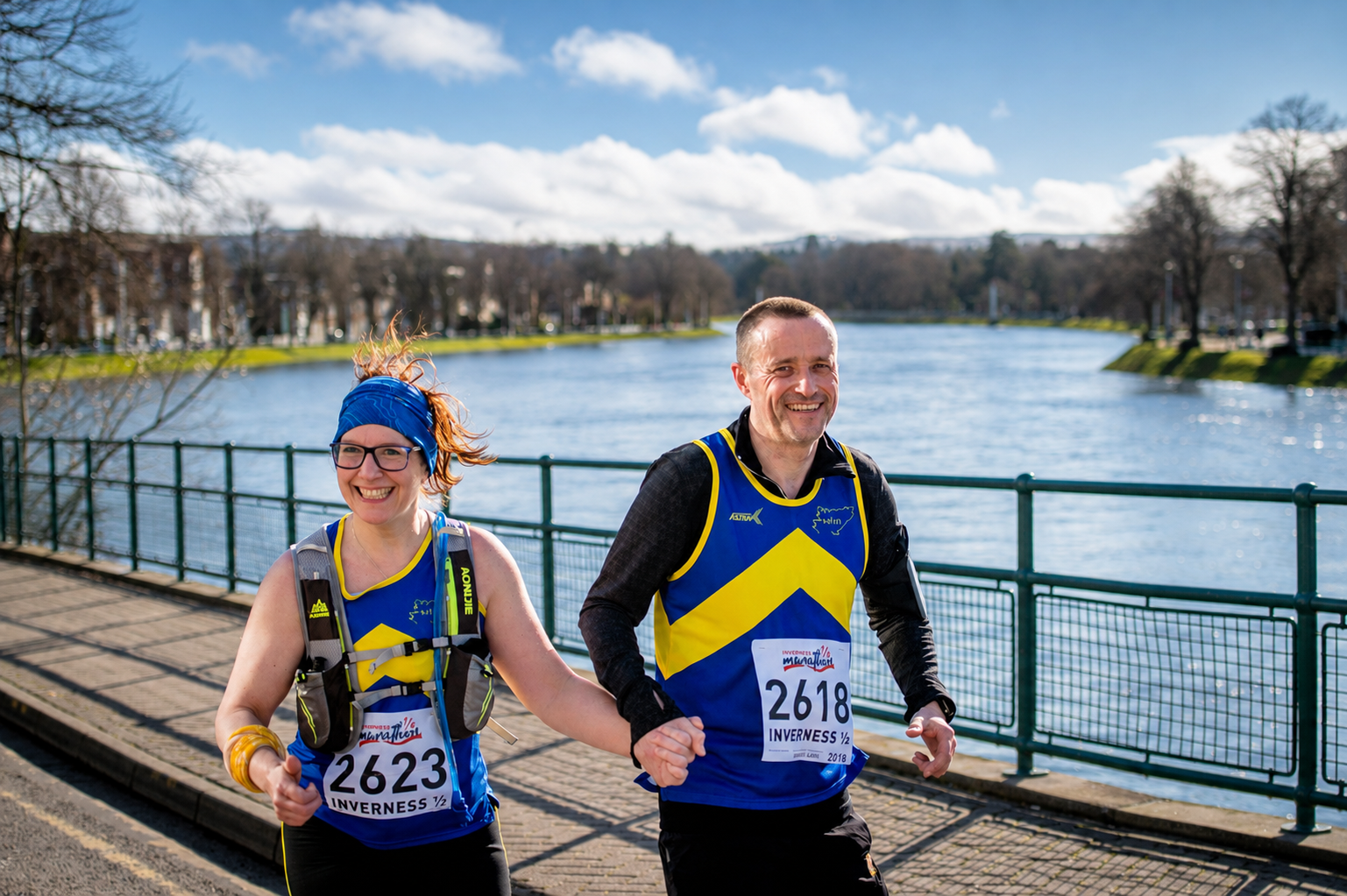Inverness Half participants hold hands and smile at the camera