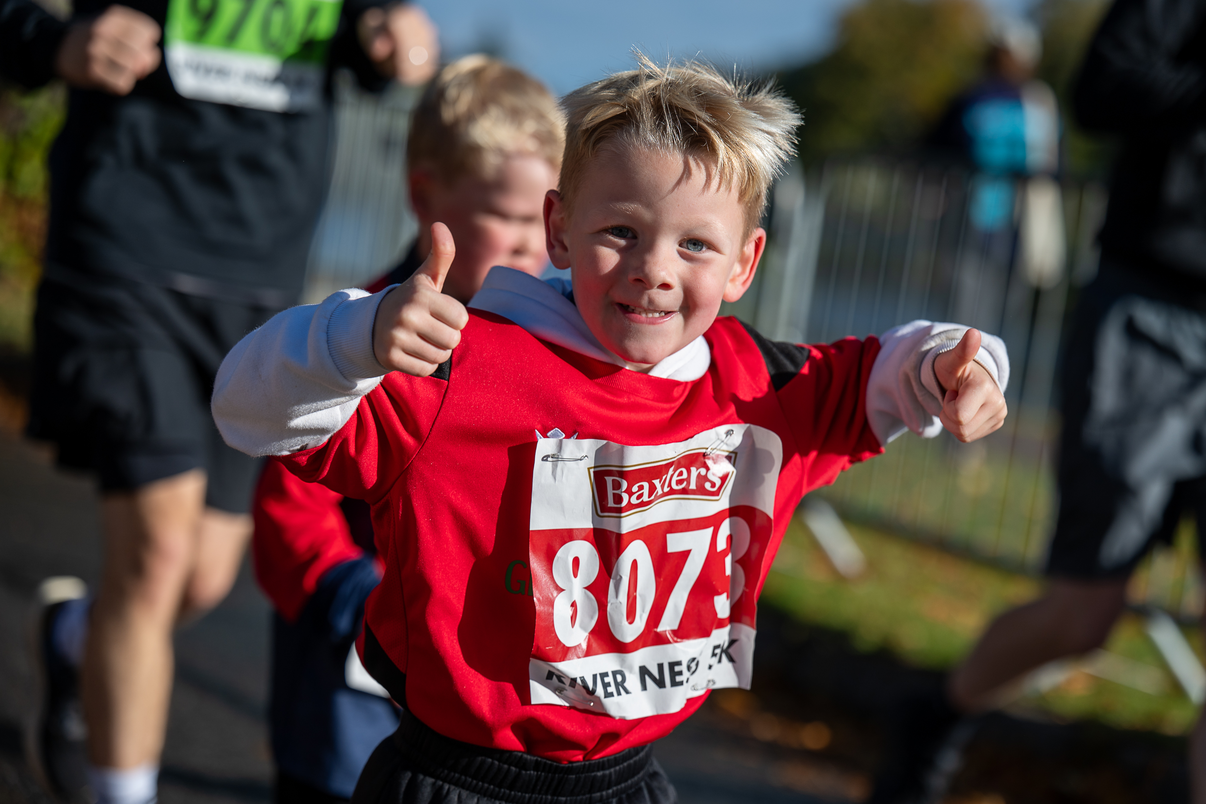 Child gives the camera a thumbs up